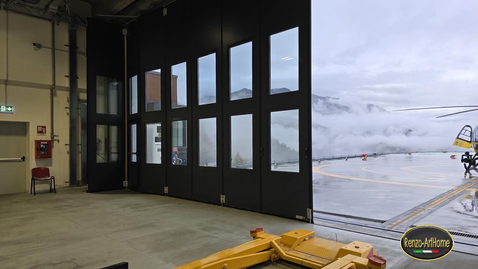 le porte a libro dell'hangar aperte verso la piazzola