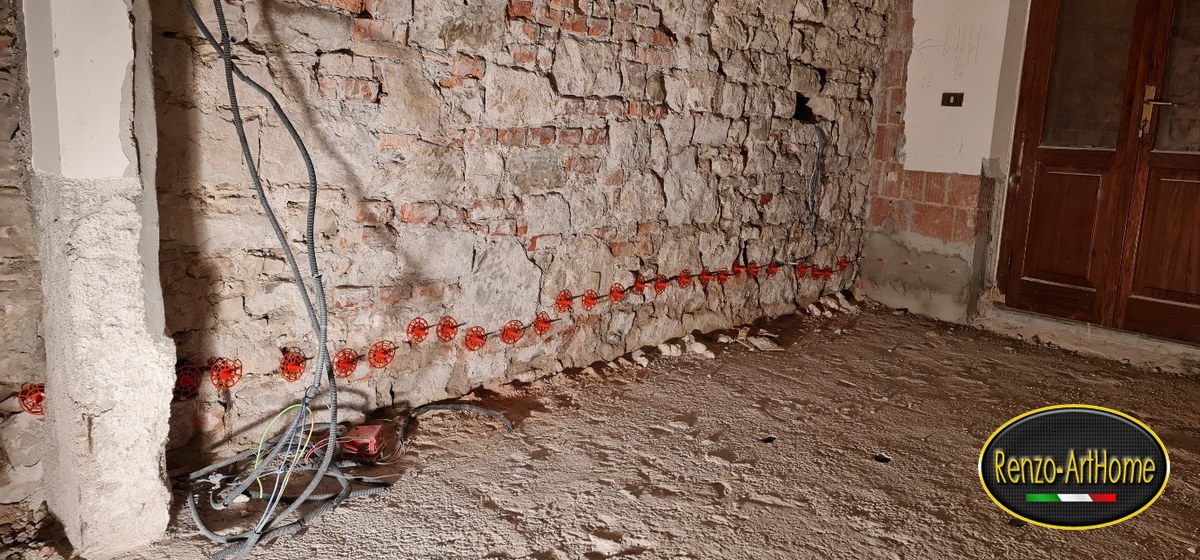 Fila di iniettori della barriera chimica alla base di una muratura in pietra
