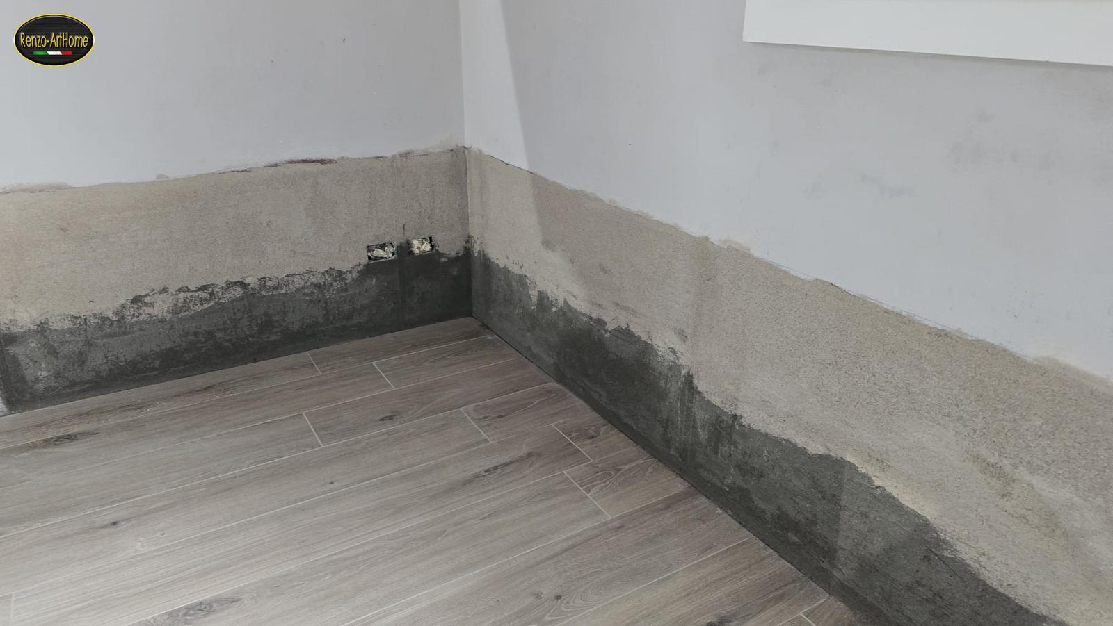 La regola del piede applicata: fascia impermeabilizzata alla base del muro e intonaco nuovo staccato da terra