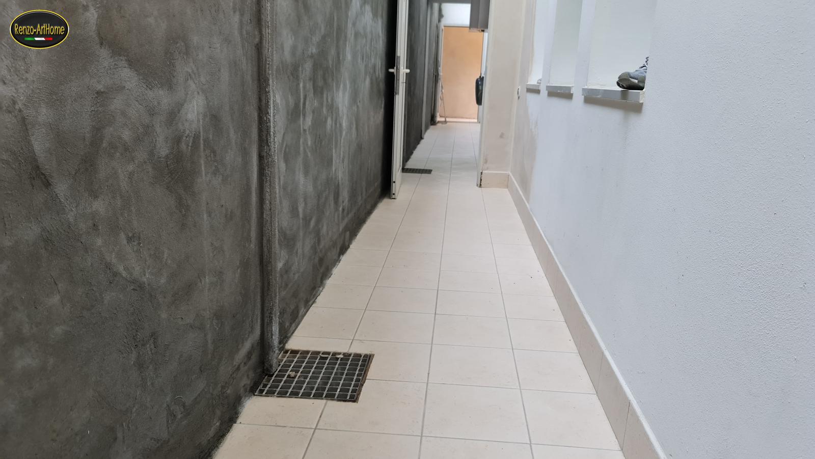 Muro di controripa trattato con boiacca impermeabilizzante in un'intercapedine, con la griglia di raccolta al piede