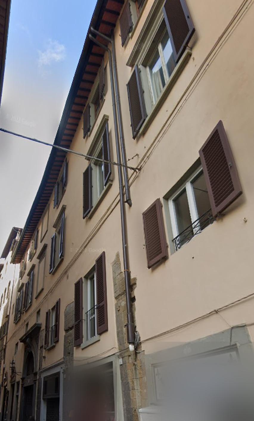 Facciata in vicolo con due tratti di pluviale murati, quello basso con segni di infiltrazione