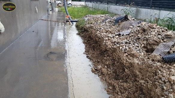 Lo scavo perimetrale allagato, visto lungo il fronte: l'acqua non ha deflusso e ristagna contro l'opera