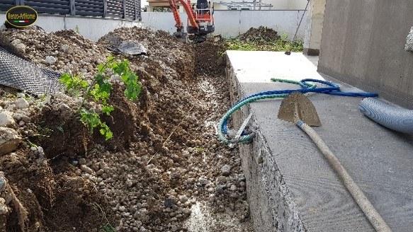 Lo scavo perimetrale in corso, con il mezzo al lavoro lungo il fronte