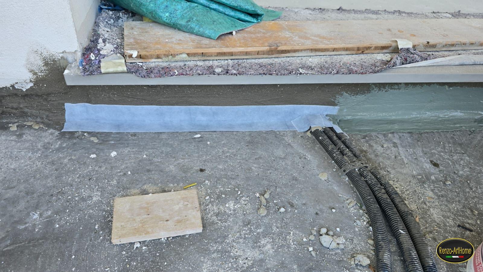 La seconda mano del rivestimento impermeabile che ingloba la bandella, con la soglia protetta da feltro e tavola