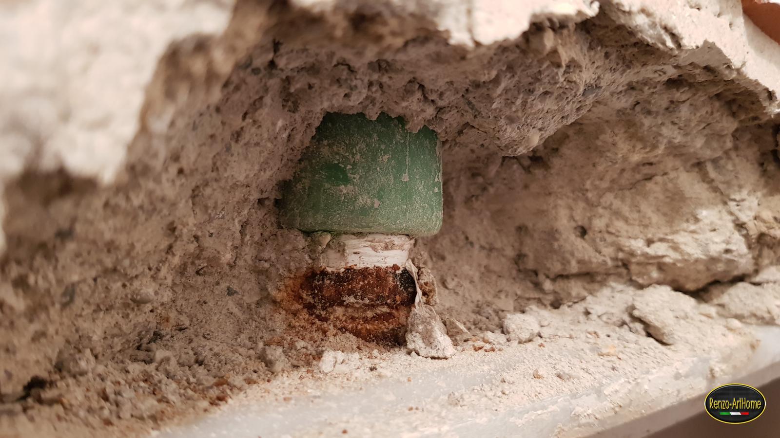 La parete aperta dietro il rivestimento: il raccordo corroso di una cassetta incassata
