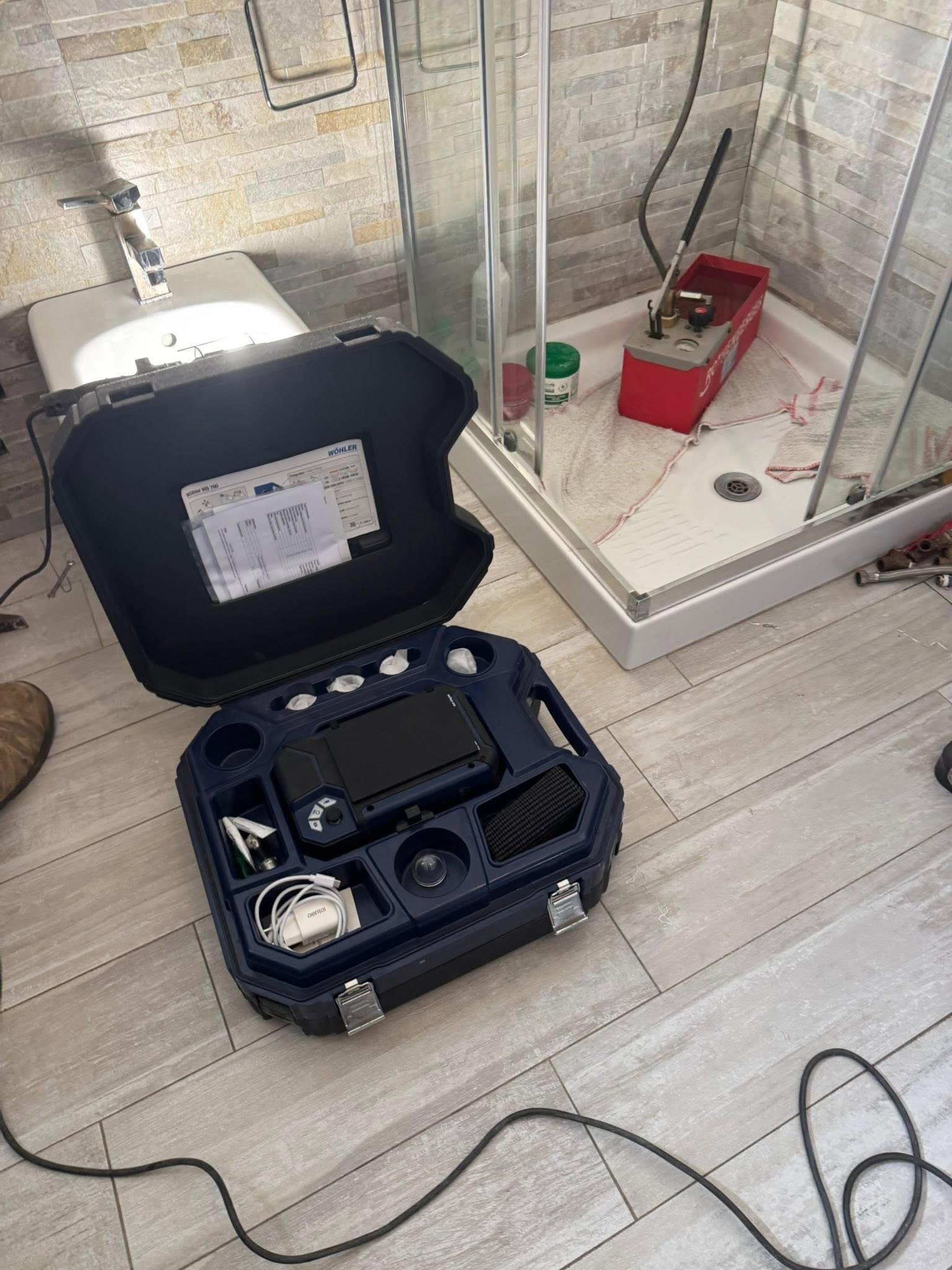 La cassetta degli strumenti di ricerca aperta accanto al piatto della doccia